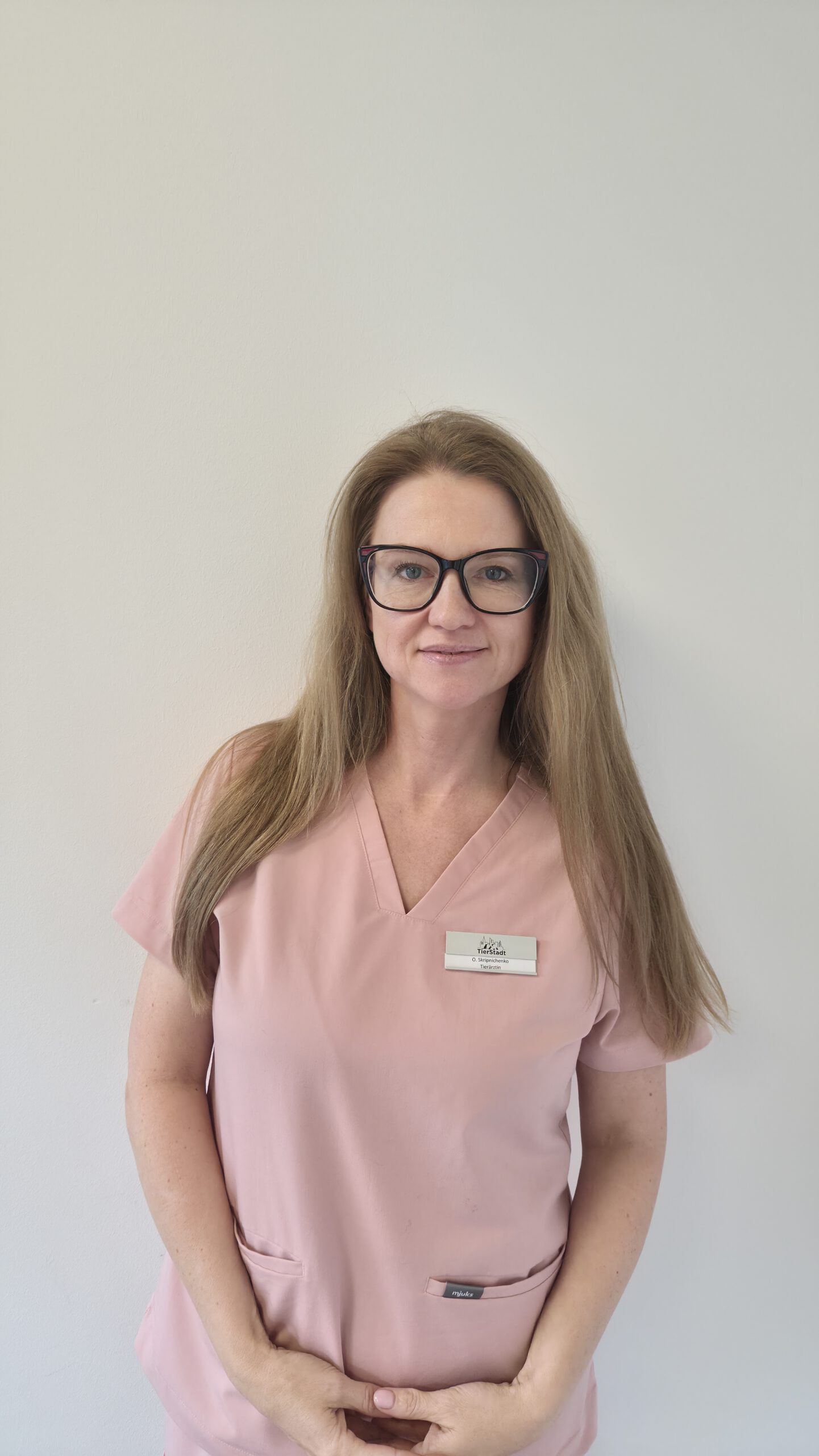 Frau in rosa Arbeitskleidung steht.