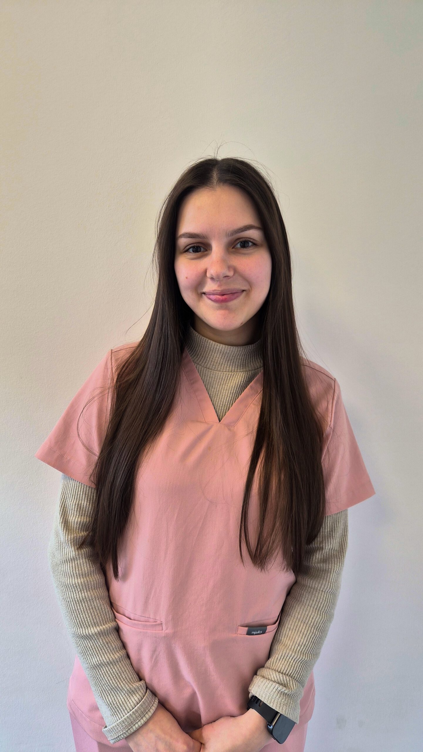 Frau in rosa Arbeitskleidung.